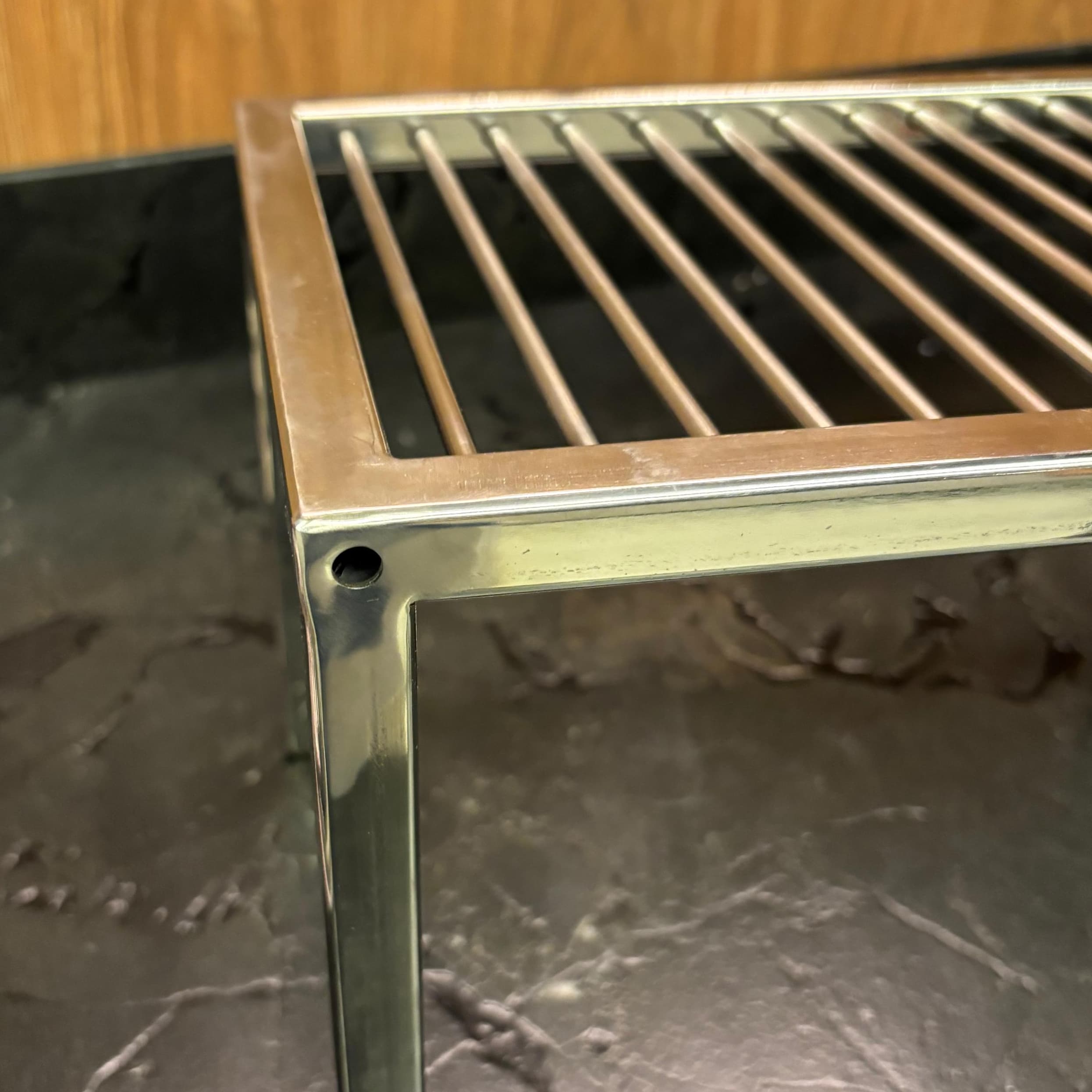 Canto da moldura de uma grelha de inox, com a solda polida e sem ressalto