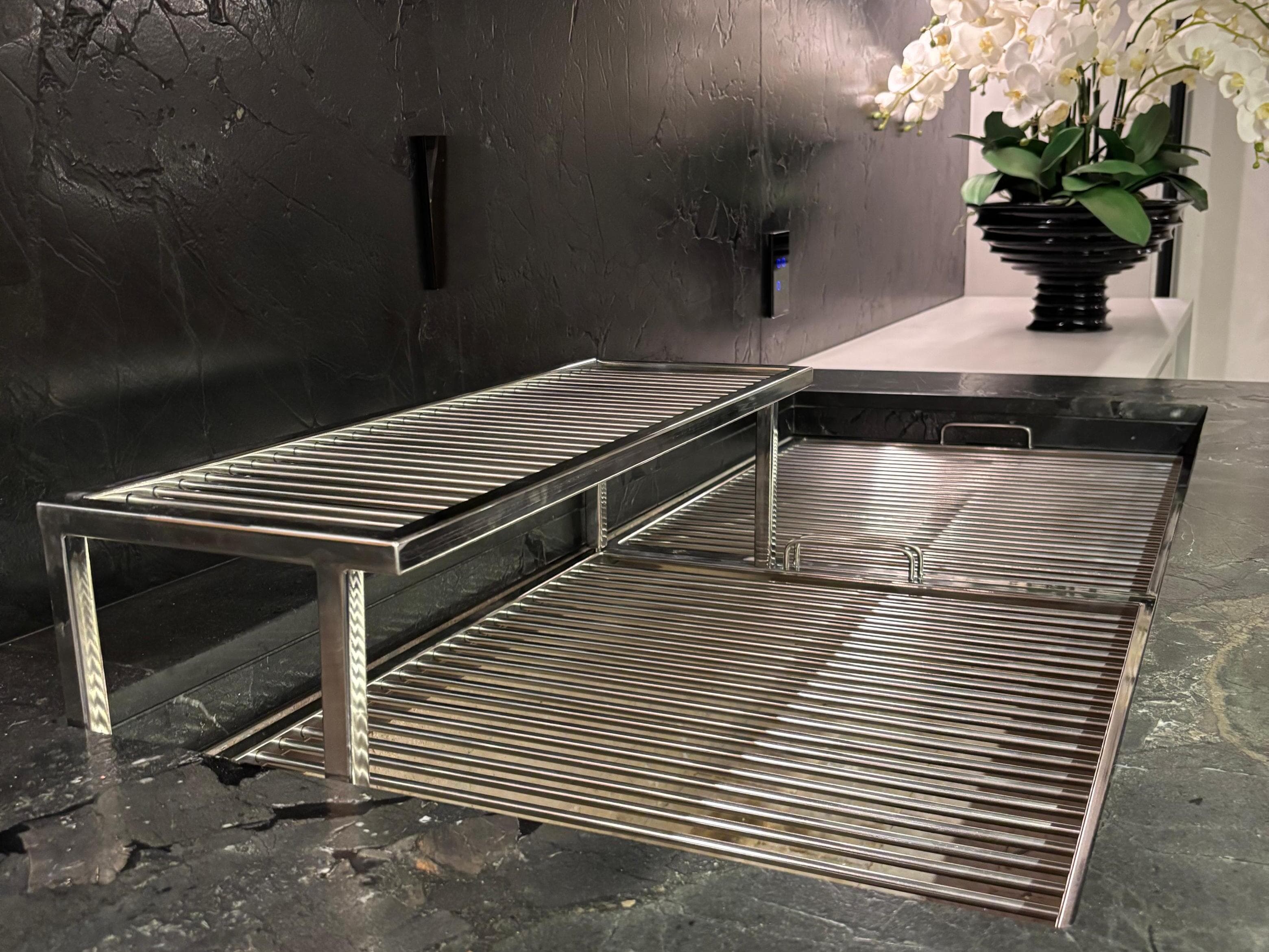 Detalhe da grelha de inox de dois níveis apoiada sobre a bancada de pedra