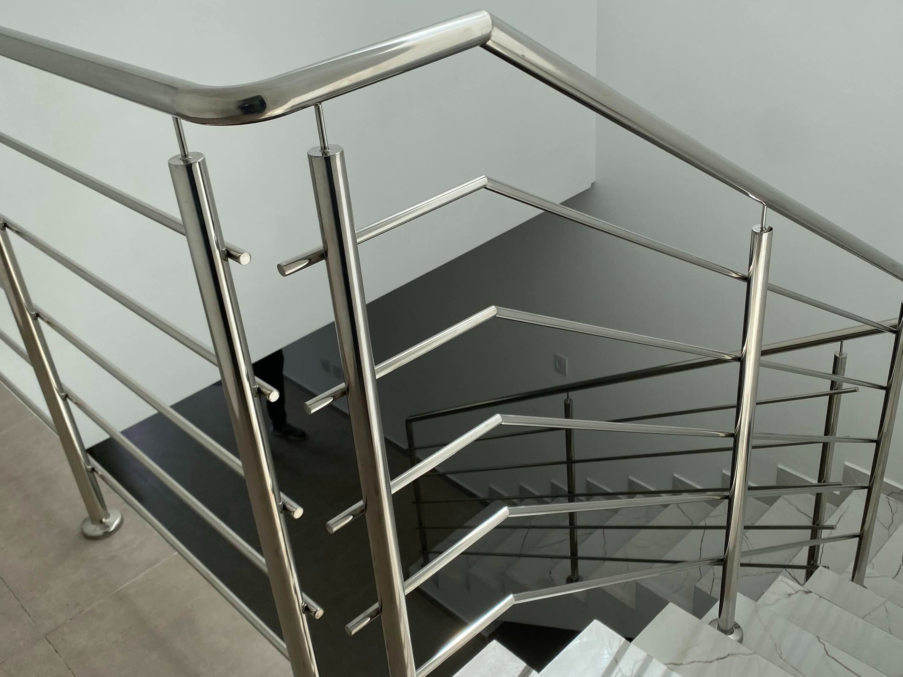 Curva do corrimão de inox acompanhando a virada do patamar, sem conexão aparente