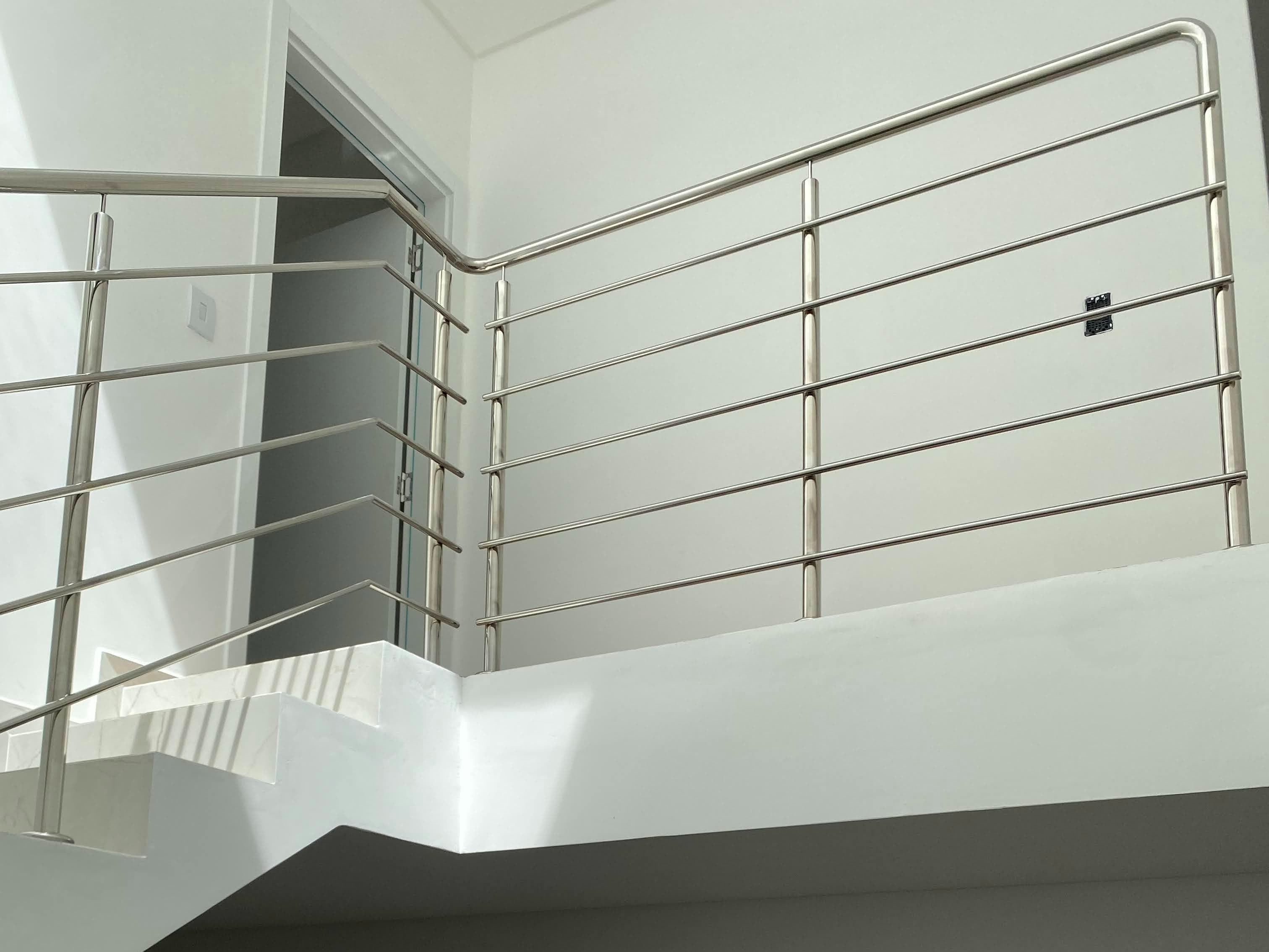 Guarda-corpo de mezanino em tubo horizontal, com a curva contornando o canto da parede